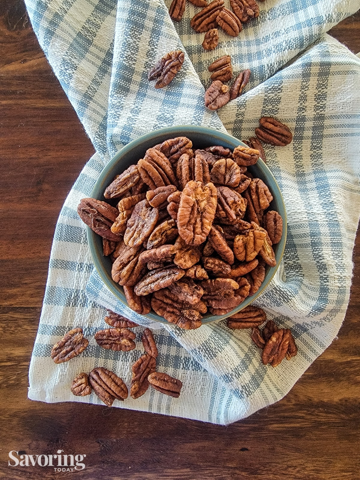 dehydrated pecans in a blue bowl on a blue striped towel
