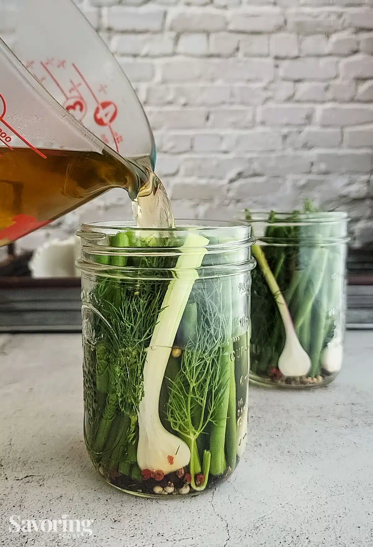 Pouring brine in a jar of green beans