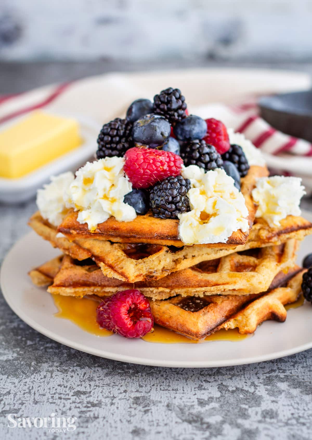 waffles topped with whipped cream and berries on a white plate