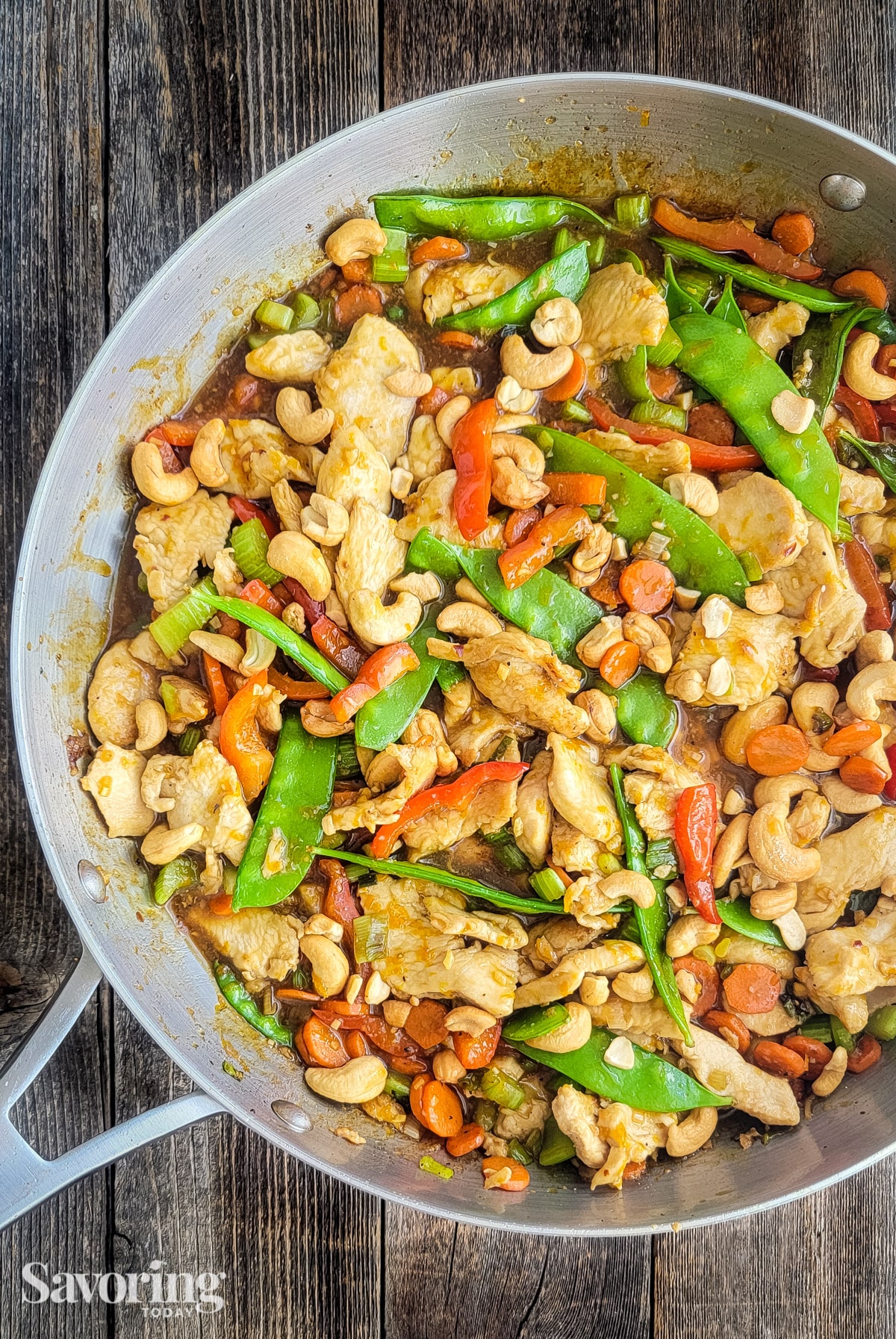 Orange Cashew Chicken Stir-Fry in a skillet on a wood table