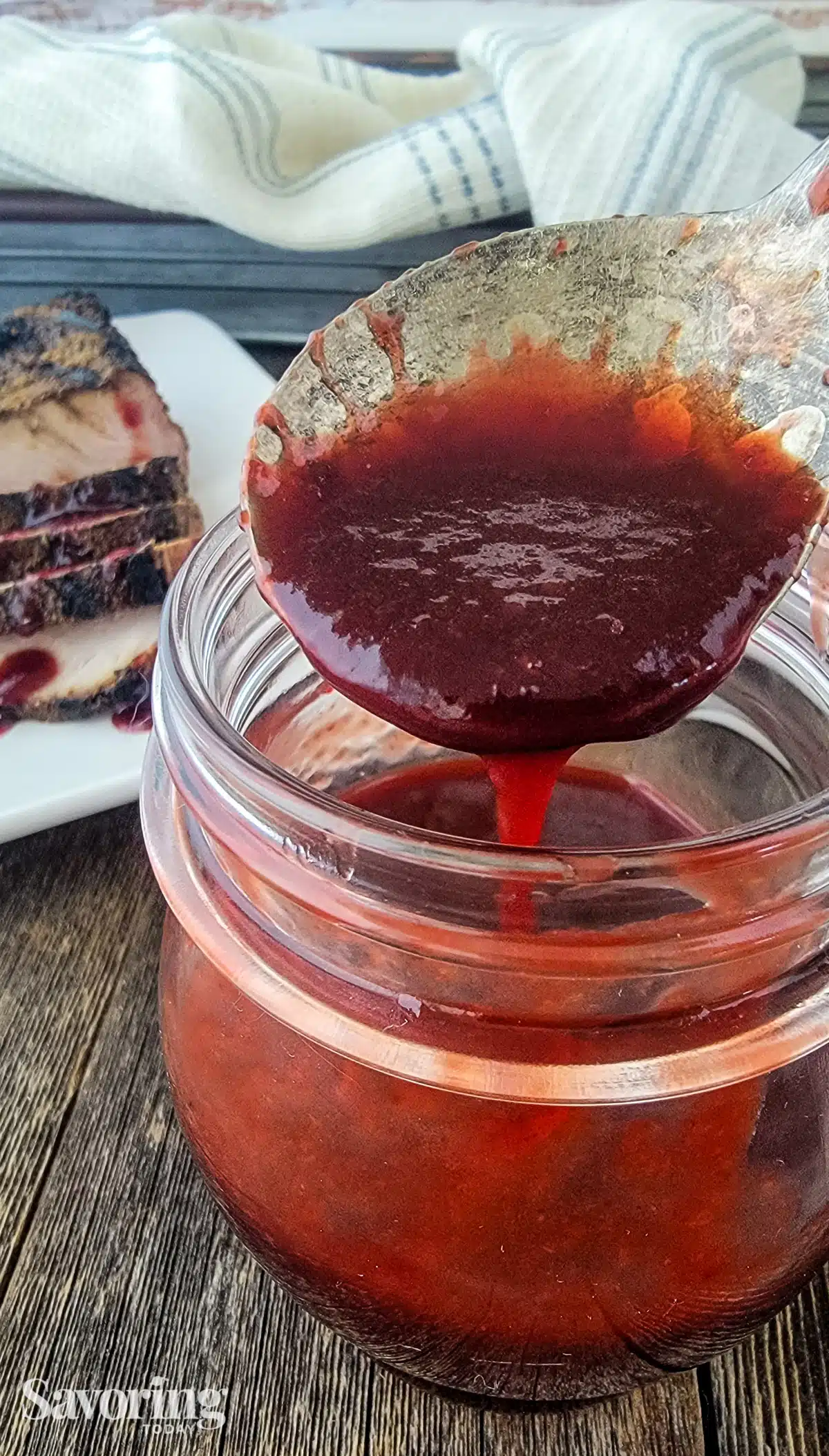 raspberry sauce on a spoon over a jar