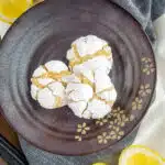 lemon cookies on a brown plate with sliced lemons