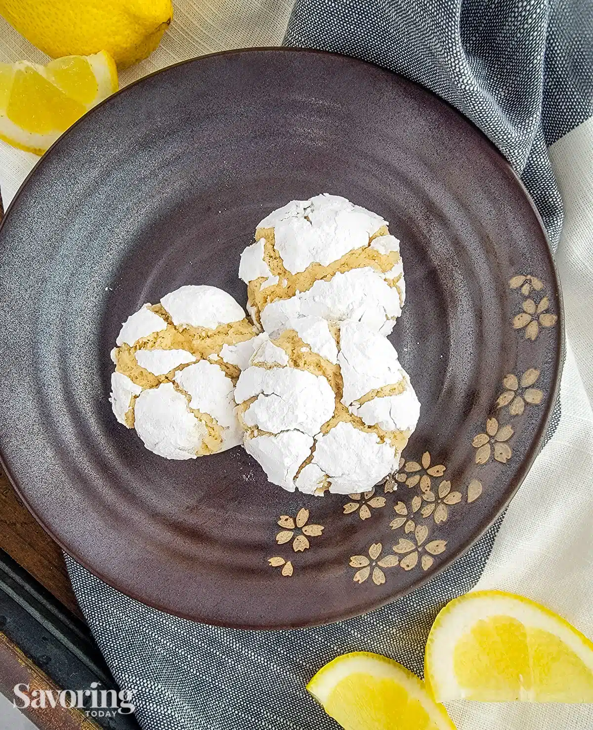 lemon cookies on a brown plate with sliced lemons