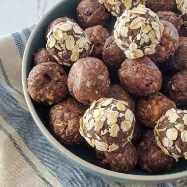 almond vanilla protein energy bites (balls) in a blue bowl on a towel