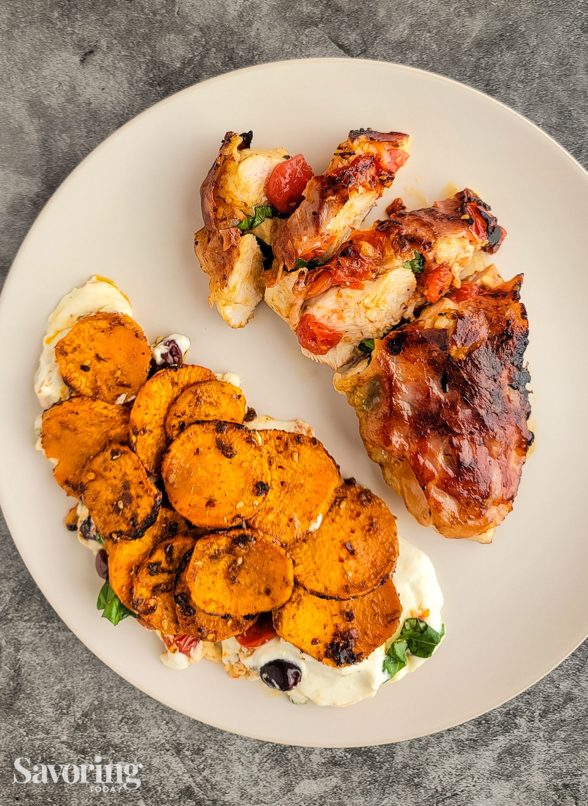 Roasted sweet potato slices over whipped ricotta on a plate with pan-seared chicken