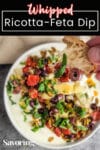 savory ricotta feta dip with roasted tomatoes dipped into and held up with pinterest banner