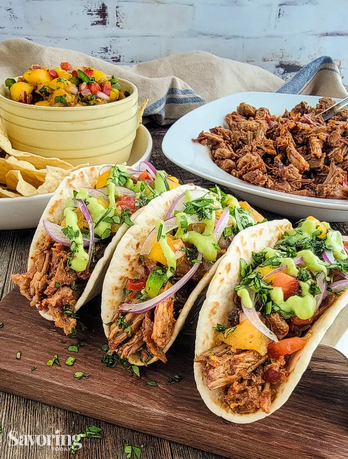 pork tacos lined up with mango salsa on the side
