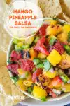 mango pineapple salsa in a white bowl with a circle title banner