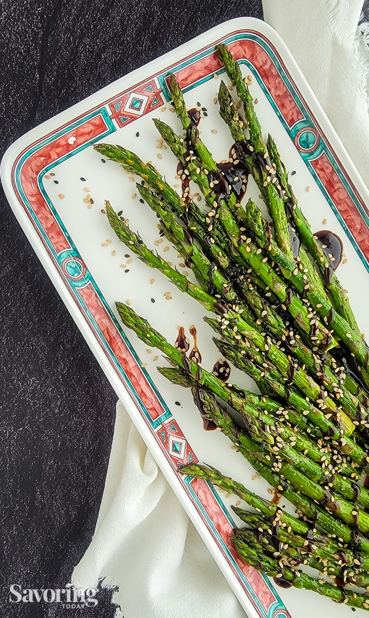 roasted asparagus with homemade 
hoisin sesame sauce on a white plate with a napkin