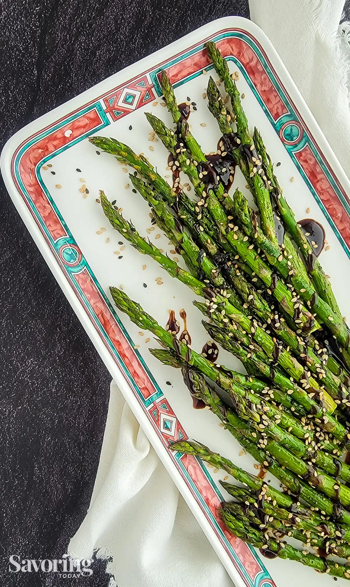 roasted asparagus with homemade 
hoisin sesame sauce on a white plate with a napkin
