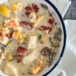 creamy seafood chowder in a white bowl on a white napkin