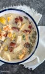 creamy seafood chowder in a white bowl on a white napkin
