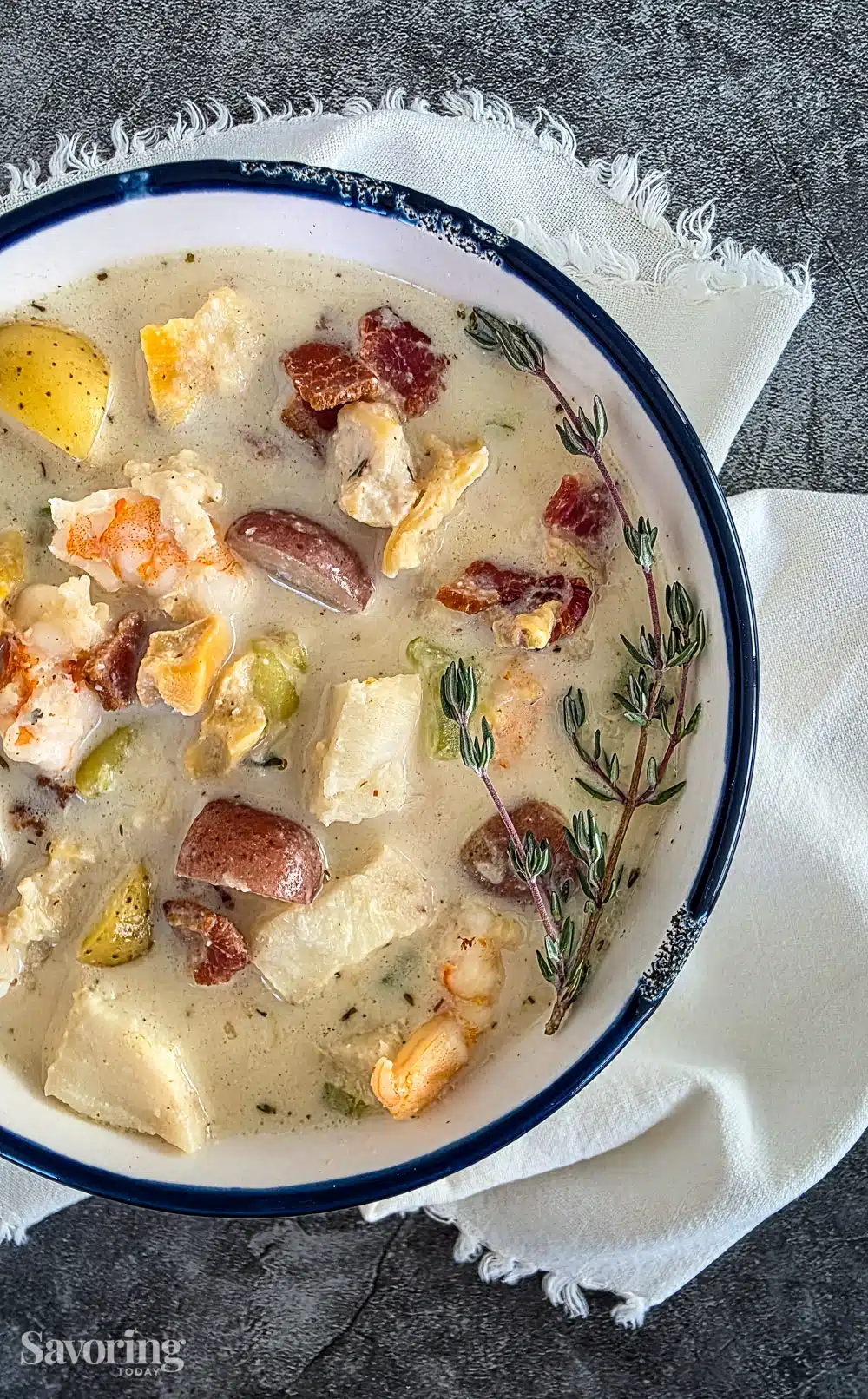creamy seafood chowder in a white bowl on a white napkin