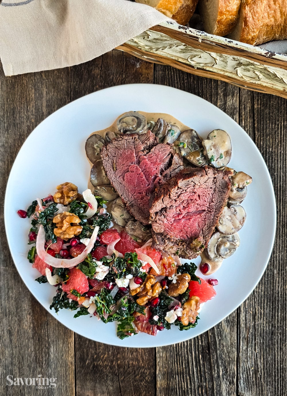 beef tenderloin with citrus salad on a white plate