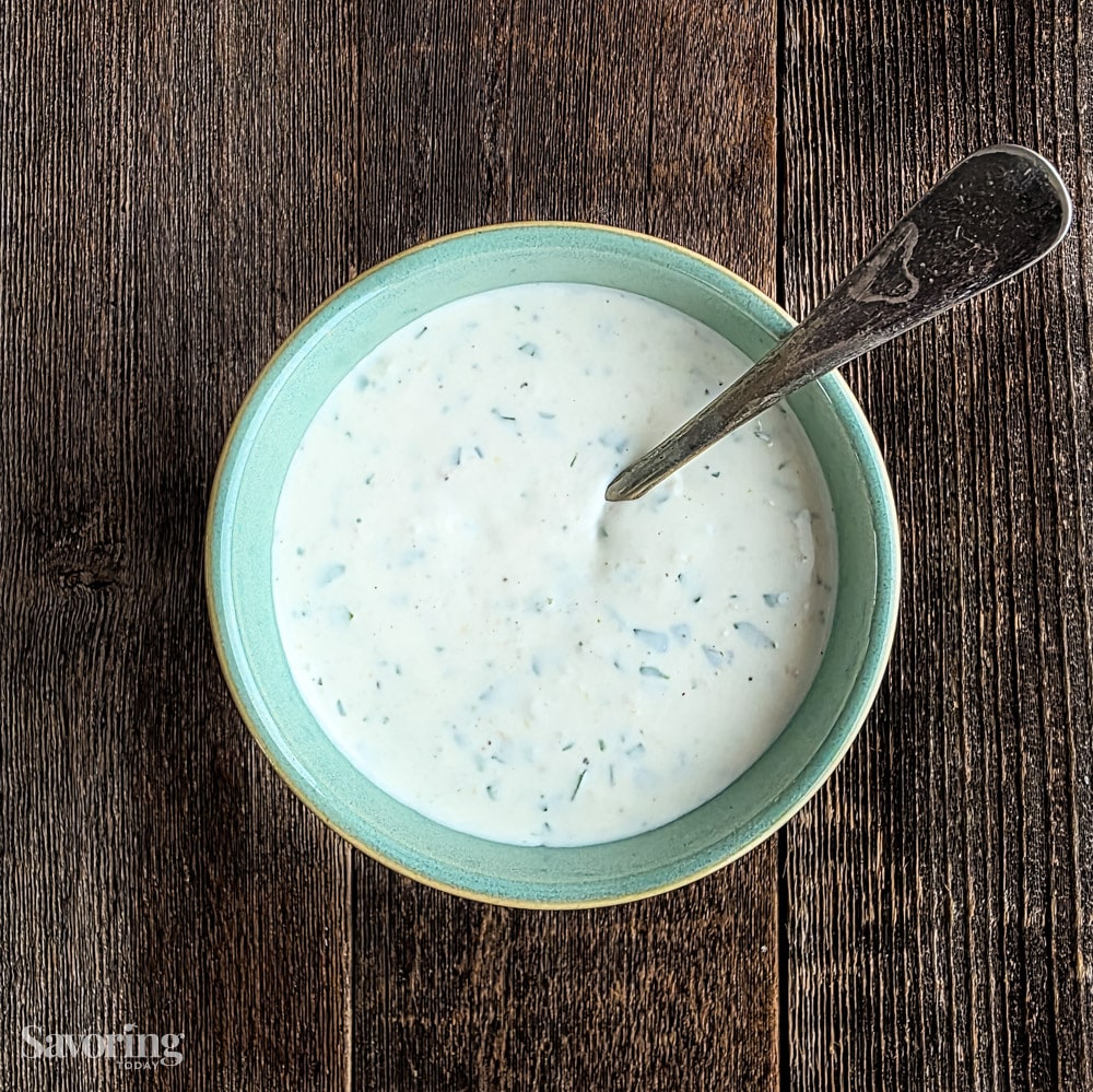Creamy Horseradish Yogurt Sauce in a blue bowl with a spoon