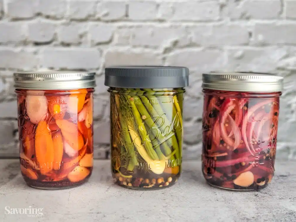 three jars of pickles on a counter
