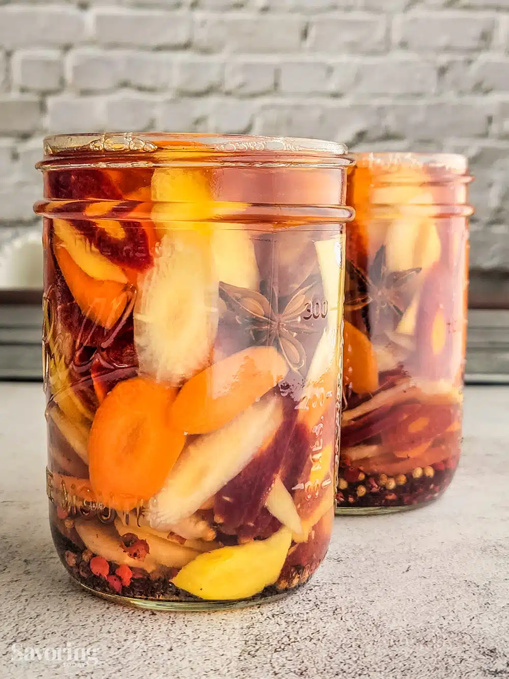pickled carrots with ginger and sumac in a jar covered in brine